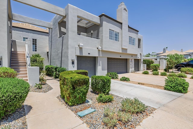 7710 E Gainey Ranch Rd E Unit 115, Scottsdale, AZ 85258 - multi unit property featuring a garage, driveway, a balcony, stucco siding, and a chimney