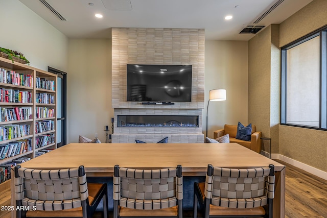 7710 E Gainey Ranch Rd E Unit 115, Scottsdale, AZ 85258 - dining space featuring a fireplace, wood finished floors, and recessed lighting