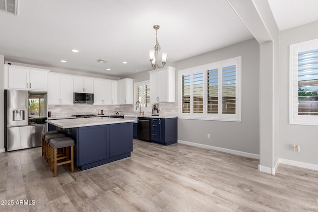 40913 W Williams Way, Maricopa, AZ 85138 - kitchen with stainless steel appliances, light countertops, white cabinets, a center island, and backsplash