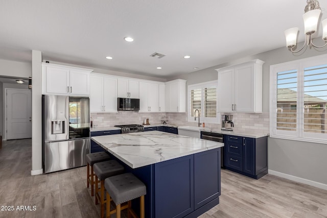 40913 W Williams Way, Maricopa, AZ 85138 - kitchen featuring stainless steel appliances, blue cabinetry, tasteful backsplash, a center island, and recessed lighting
