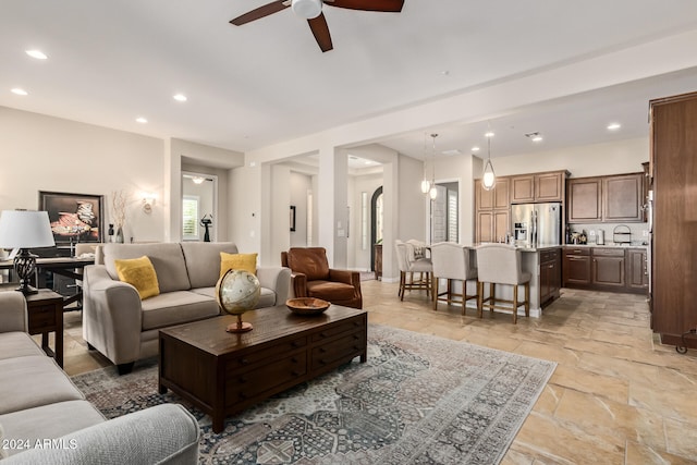 living room with ceiling fan and sink