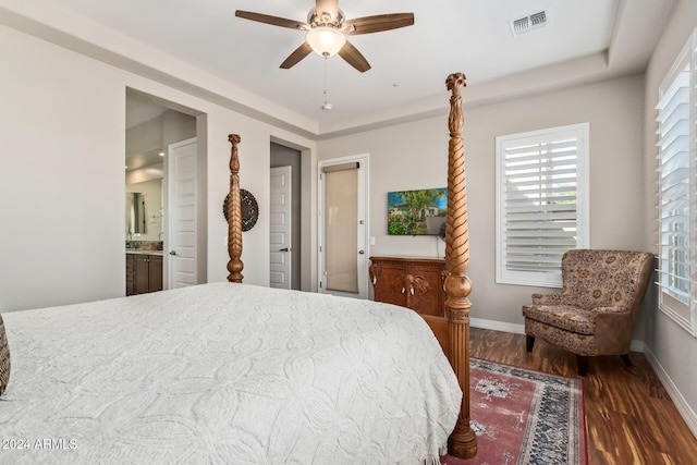 bedroom featuring ceiling fan, dark hardwood / wood-style flooring, and connected bathroom