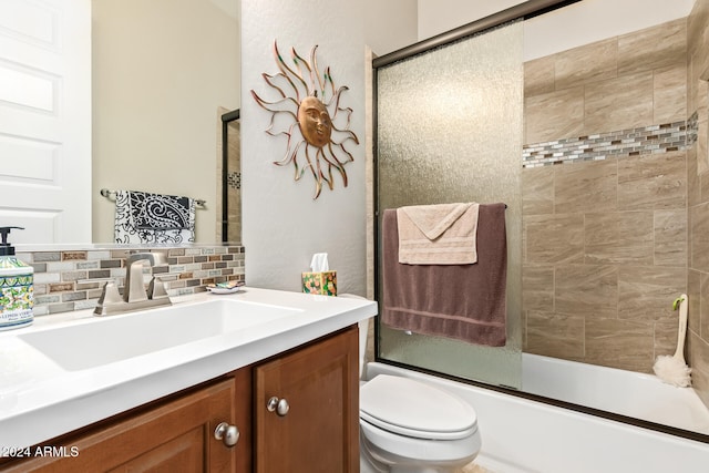 full bathroom featuring vanity, toilet, shower / bath combination with glass door, and tasteful backsplash