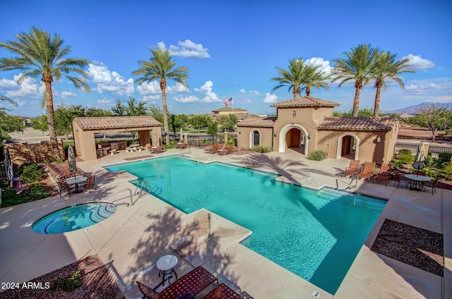 view of swimming pool with a patio area and a community hot tub