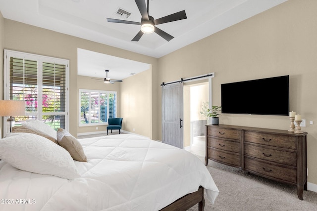 bedroom featuring visible vents, a barn door, ceiling fan, and carpet flooring