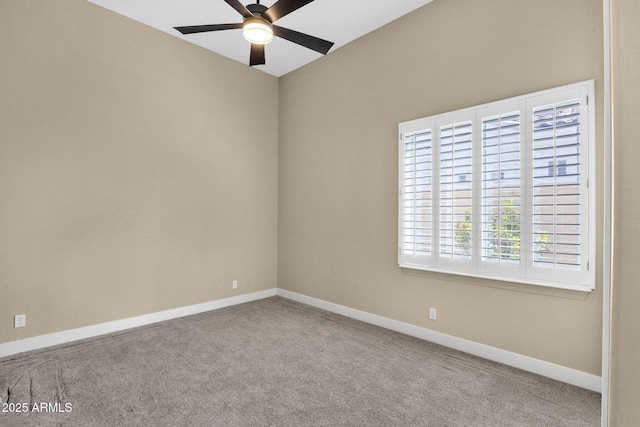 carpeted spare room with ceiling fan and baseboards