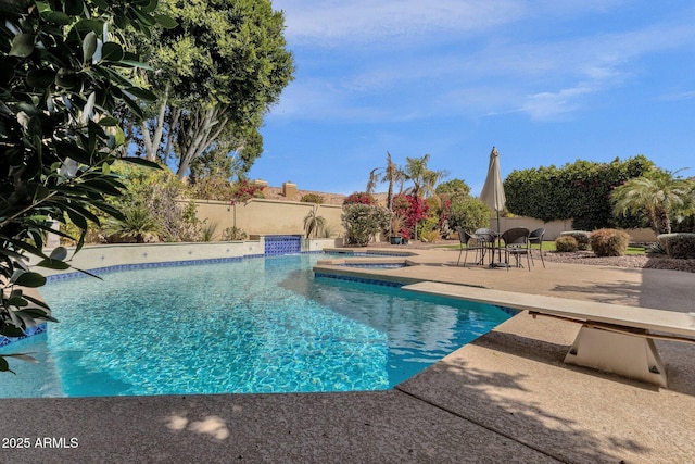 pool featuring a patio area, an in ground hot tub, and fence