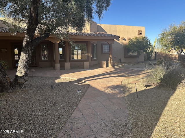 southwest-style home with a tile roof and stucco siding