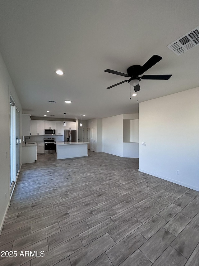 unfurnished living room featuring ceiling fan