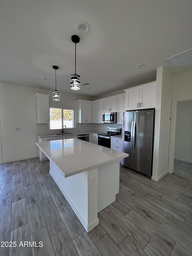 kitchen with a center island, sink, white cabinetry, and stainless steel appliances