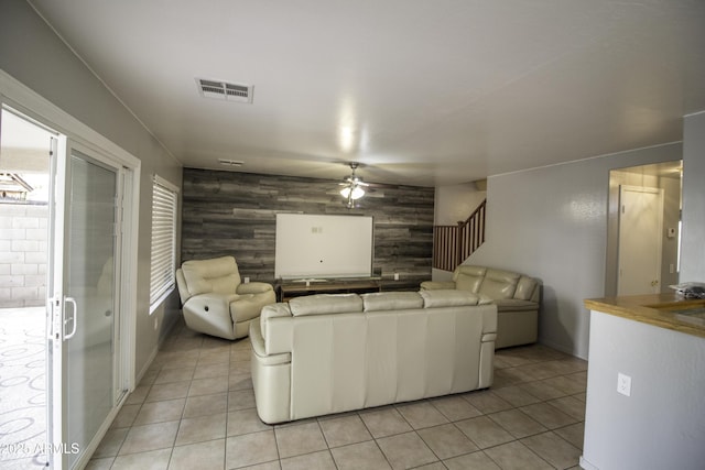 20221 N 31st St, Phoenix, AZ 85050 - living room with a ceiling fan, light tile patterned floors, an accent wall, wooden walls, and stairs