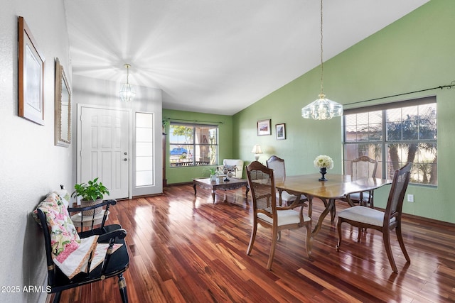 dining room featuring an inviting chandelier, lofted ceiling, and wood-type flooring