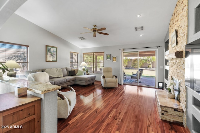 living room featuring ceiling fan, lofted ceiling, dark hardwood / wood-style flooring, and a fireplace