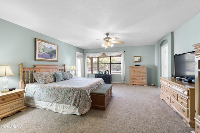 bedroom featuring ceiling fan, light carpet, and a textured ceiling