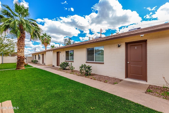 ranch-style home with a front lawn and fence