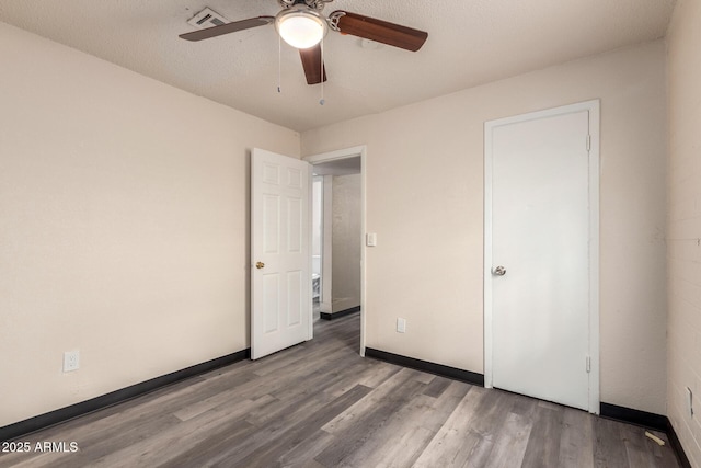 unfurnished bedroom with visible vents, baseboards, and wood finished floors