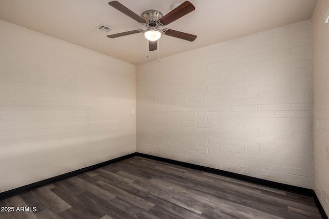 empty room with ceiling fan, dark wood-style flooring, visible vents, and baseboards