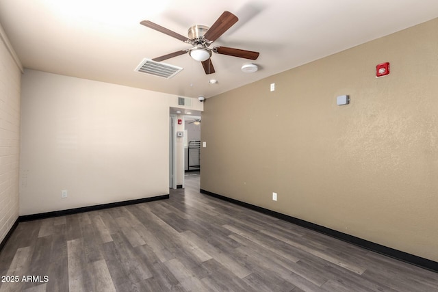 spare room with ceiling fan, wood finished floors, visible vents, and baseboards