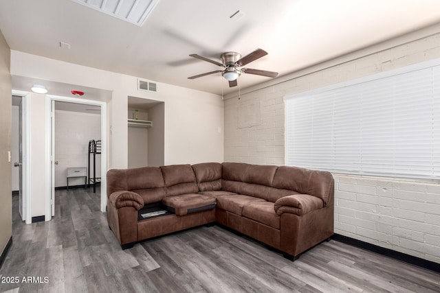 living room with visible vents, ceiling fan, and wood finished floors