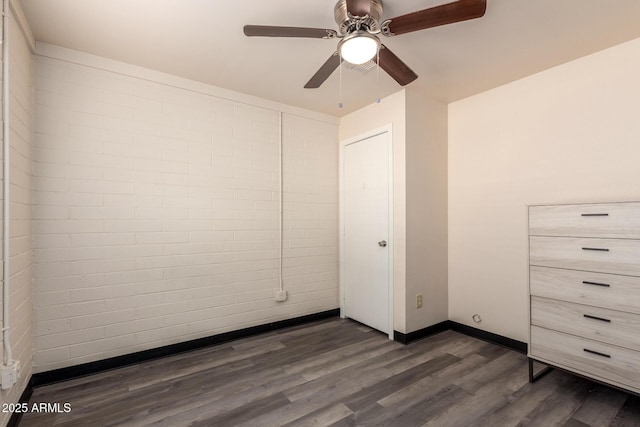 unfurnished bedroom featuring dark wood finished floors, baseboards, and ceiling fan