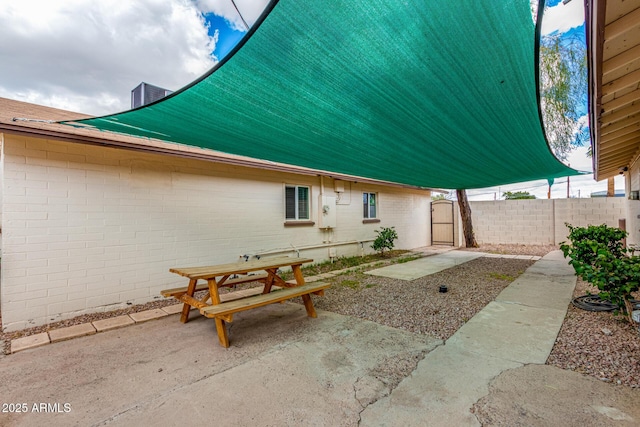 back of property with outdoor dining space, brick siding, a patio, and fence