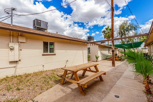 back of property with central AC unit, a patio area, and outdoor dining space