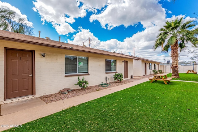 single story home with brick siding and a front yard