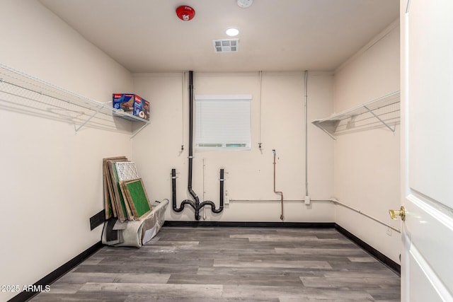 washroom featuring baseboards, visible vents, and wood finished floors