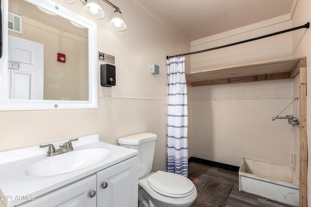 bathroom with visible vents, toilet, ornamental molding, wood finished floors, and vanity