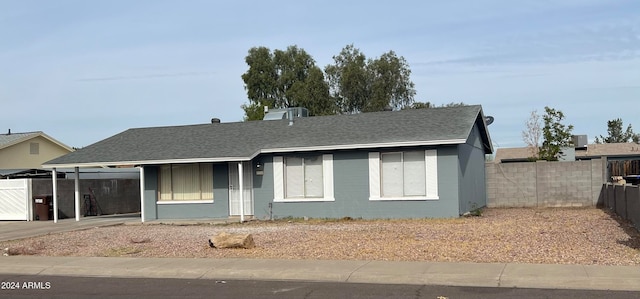 ranch-style house with central AC and a carport