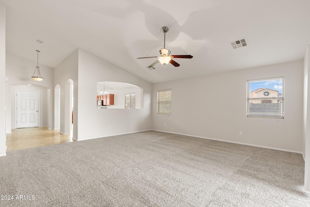 spare room with ceiling fan, light carpet, and vaulted ceiling