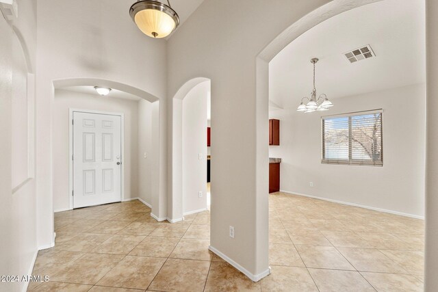 entrance foyer featuring light tile patterned flooring and an inviting chandelier