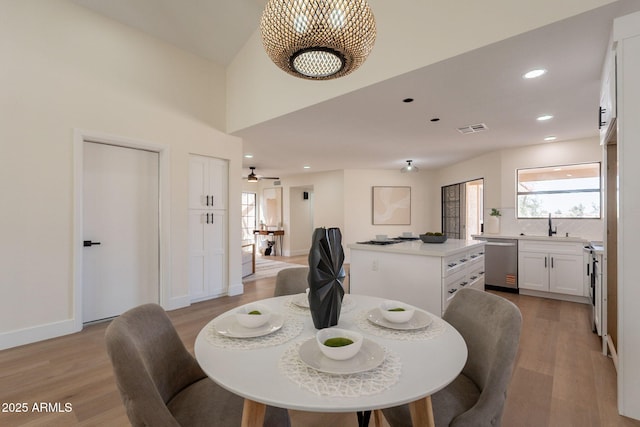 dining room featuring baseboards, light wood-type flooring, visible vents, and recessed lighting