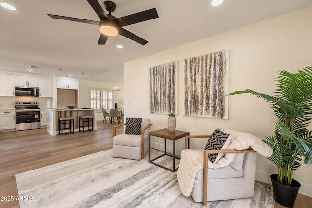 sitting room with recessed lighting, baseboards, light wood finished floors, ceiling fan, and visible vents