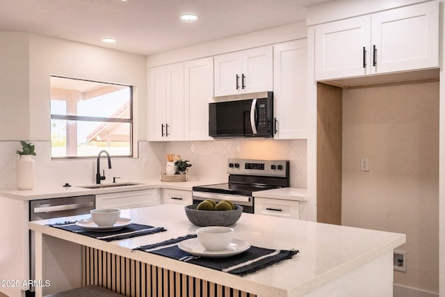 kitchen featuring white cabinetry, light countertops, appliances with stainless steel finishes, and a sink