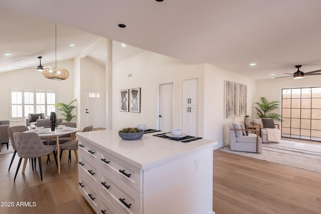 kitchen featuring ceiling fan, light wood-style flooring, and open floor plan