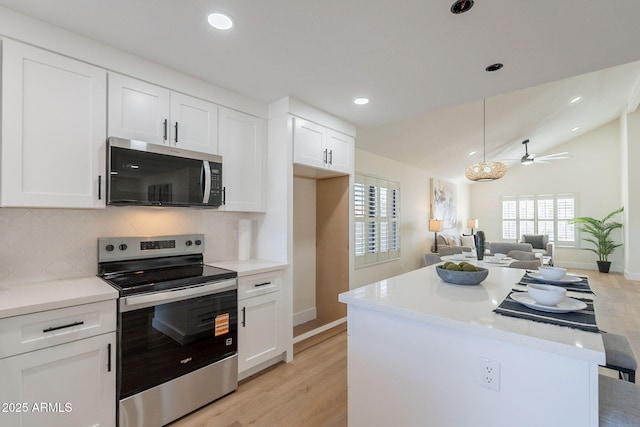 kitchen featuring white cabinetry, light wood finished floors, tasteful backsplash, and appliances with stainless steel finishes