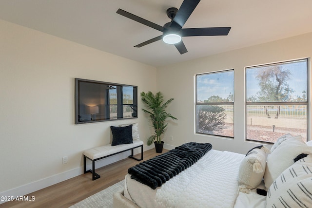 bedroom featuring a ceiling fan, wood finished floors, and baseboards
