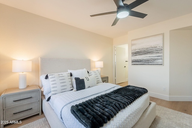 bedroom featuring baseboards, a ceiling fan, and wood finished floors