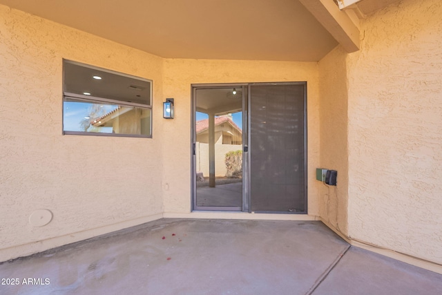 property entrance featuring a patio and stucco siding