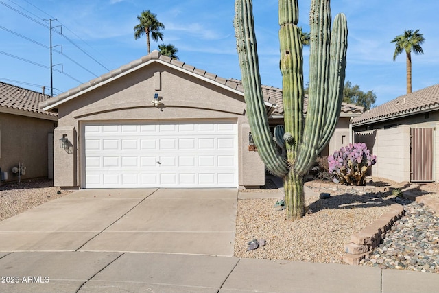 single story home featuring concrete driveway, a tile roof, an attached garage, fence, and stucco siding