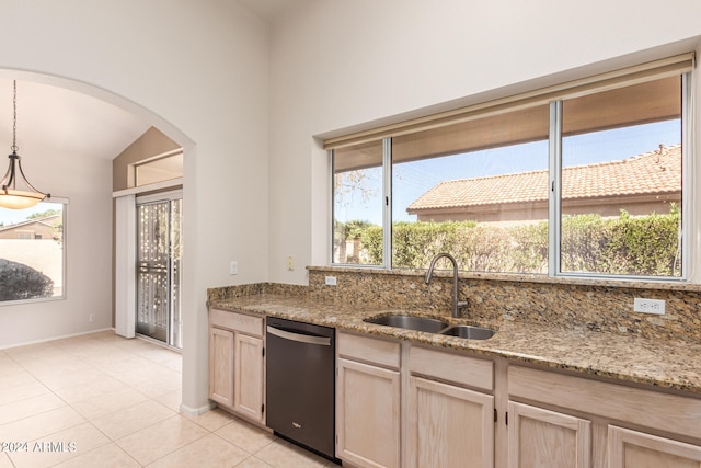 kitchen featuring decorative backsplash, light brown cabinetry, sink, light stone countertops, and stainless steel dishwasher