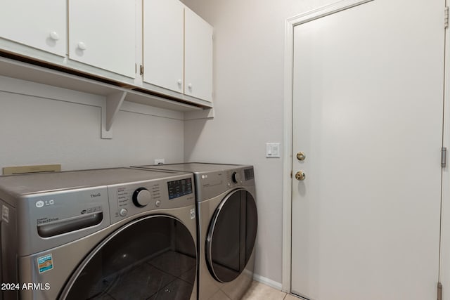 laundry area with cabinets, washer and dryer, and light tile patterned floors