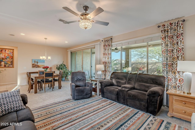 living area featuring light tile patterned floors, visible vents, recessed lighting, and ceiling fan with notable chandelier