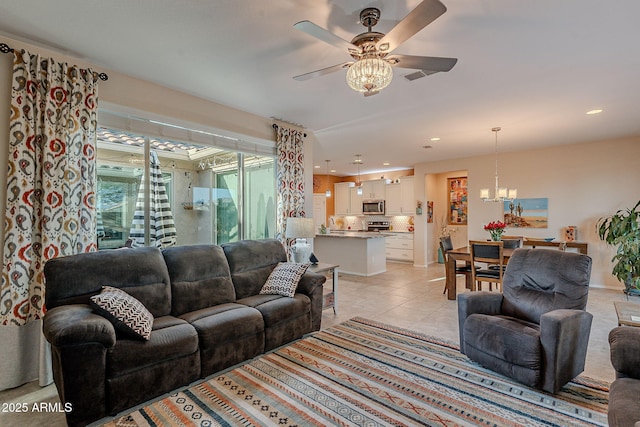 living room featuring ceiling fan with notable chandelier, light tile patterned floors, and recessed lighting