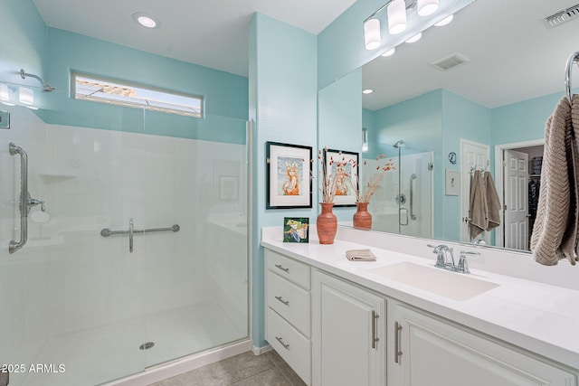 bathroom featuring tile patterned floors, visible vents, a stall shower, and vanity