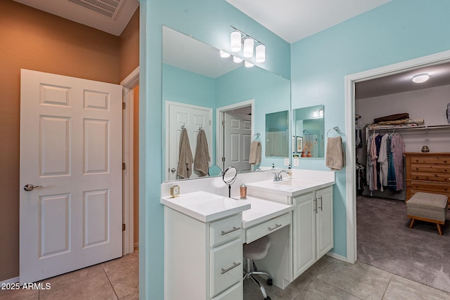 bathroom with tile patterned floors, visible vents, a spacious closet, and vanity