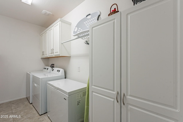 laundry room featuring cabinet space, baseboards, and washing machine and clothes dryer