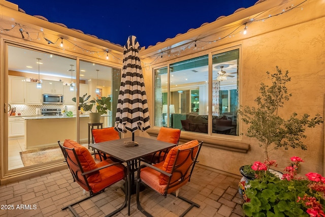 patio at night featuring outdoor dining space