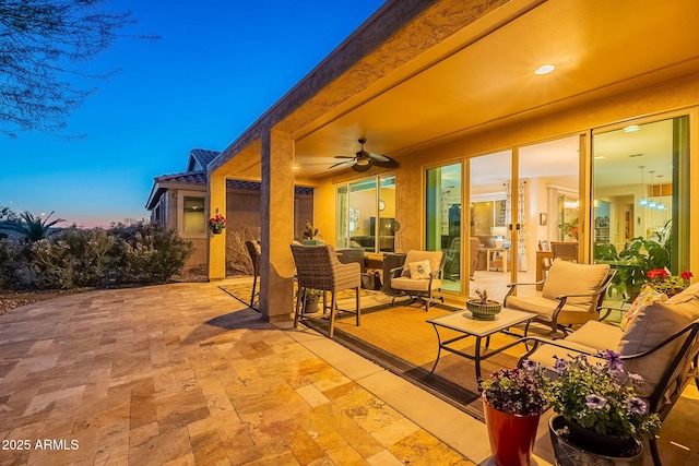 patio terrace at dusk featuring an outdoor hangout area and a ceiling fan